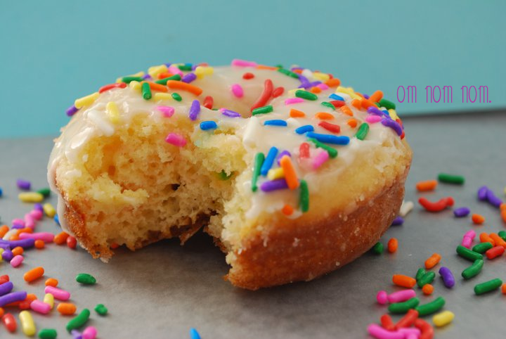 Close-up of a twice-glazed Funfetti cake donut with a bite missing