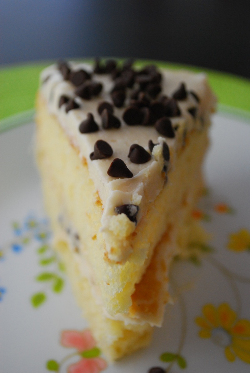 Close-up of a slice of chocolate chip cookie dough cake on a white flower plate