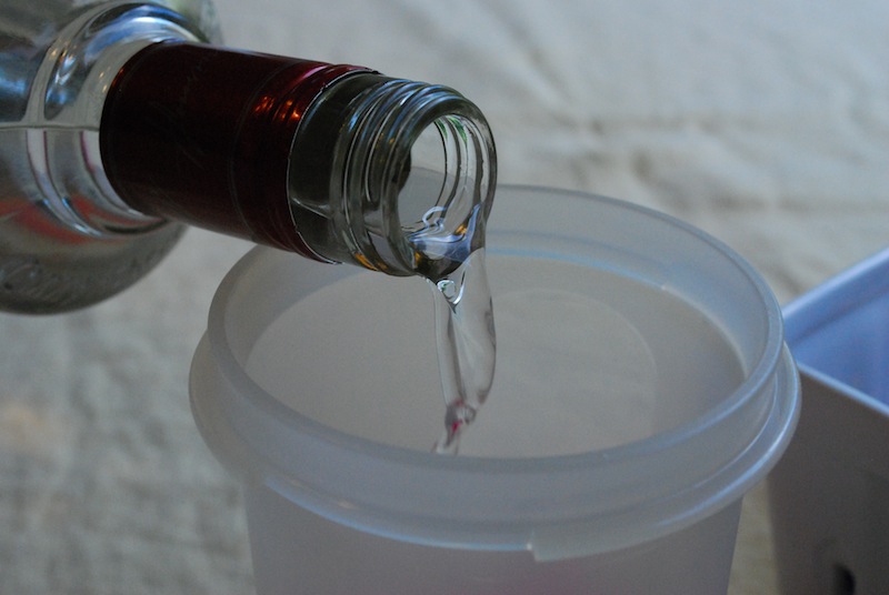 Vodka being poured from a bottle into a container