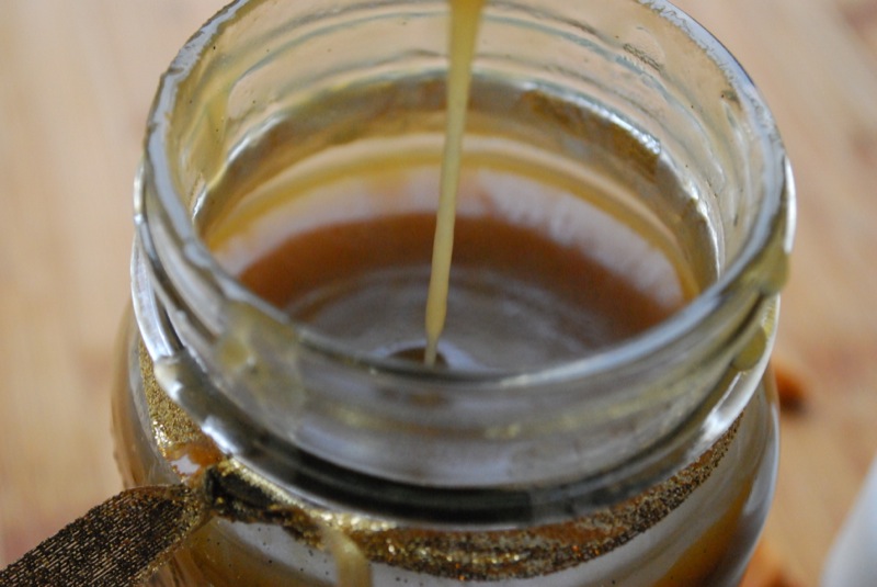 Vanilla bean butterscotch sauce being poured into a jar