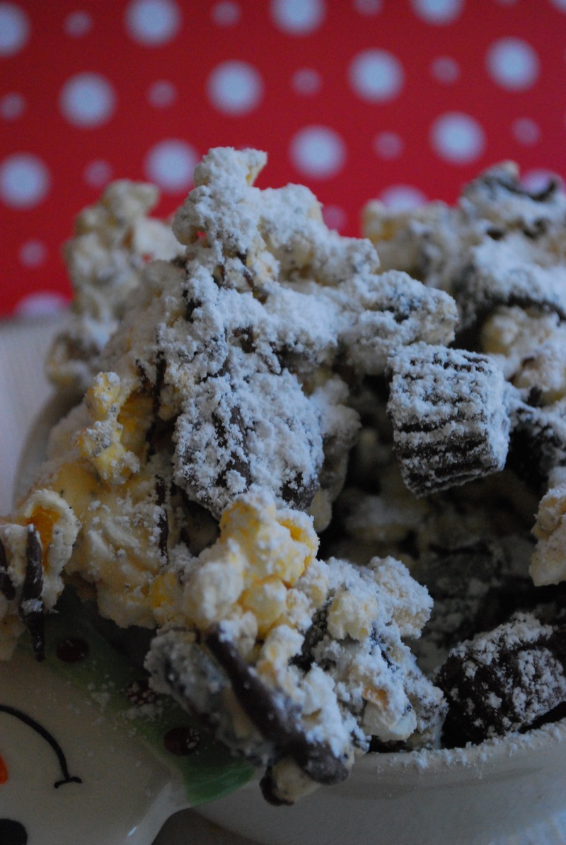 Close-up of cookies and cream reese's cup puppy chow popcorn in front of a red and white background