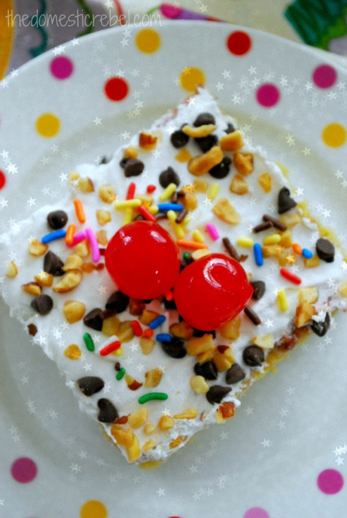 banana split poke cake on a polka dotted plate with stars in background