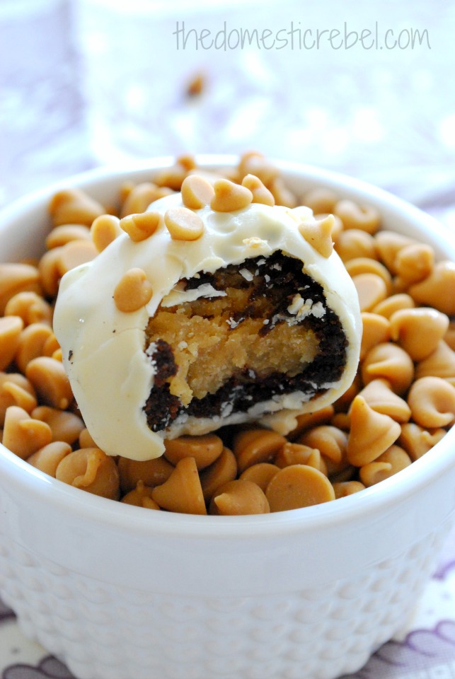 peanut butter cookie dough brownie bombs with a bite taken out of it on a bed of peanut butter chips