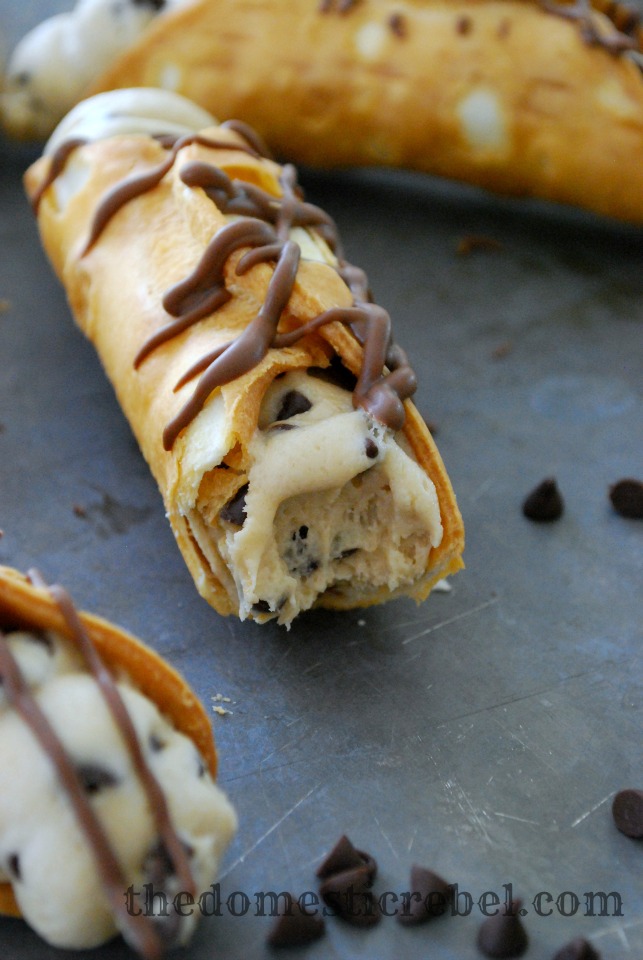 chocolate chip cookie dough cannolis closeup on a metal baking sheet with a bite removed