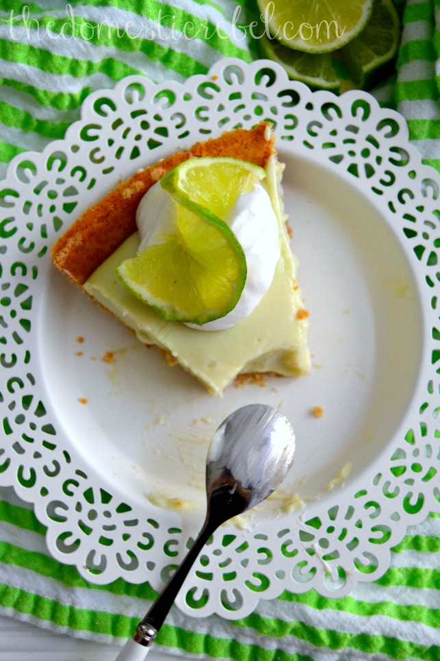 guiltless key lime pie slice on white plate and green background with spoon