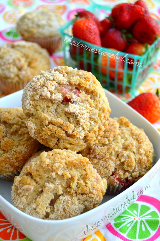 strawberry crumb muffins arranged in white dish with strawberries in background