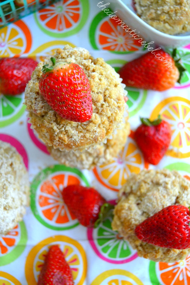 strawberry crumb muffins arranged on colorful dish towel with fresh strawberries