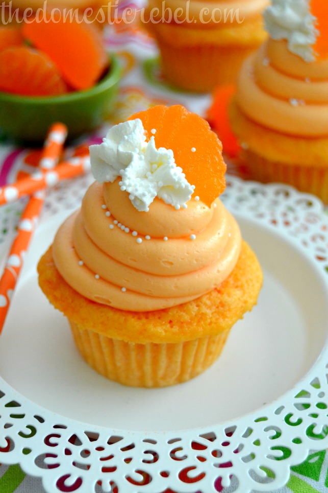 orange creamsicle cupcakes on white plate with cupcakes in background