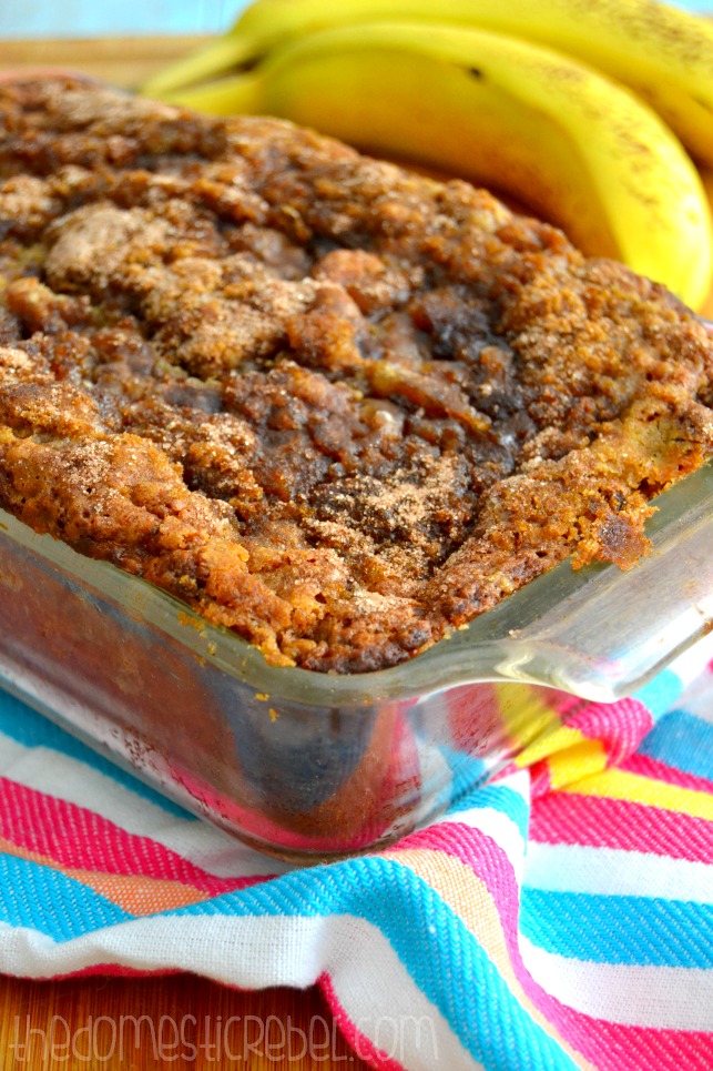photo of banana bread in glass loaf pan with bananas in background