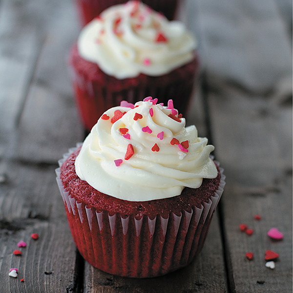 The-Best-Red-Velvet-Cupcakes arranged in a row on wood background