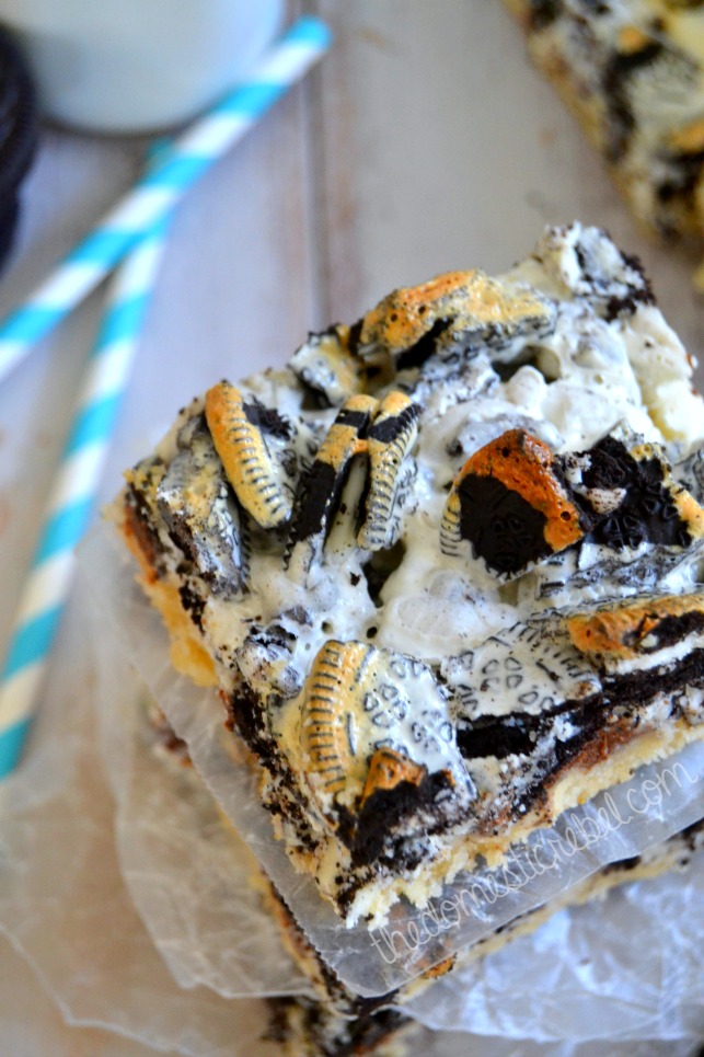 cookies n cream seven layer bars stacked with two blue straws in background