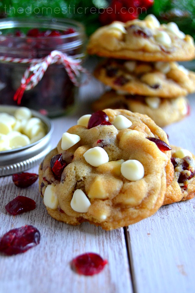 white chocolate cranberry cookies on a white background with cranberries scattered