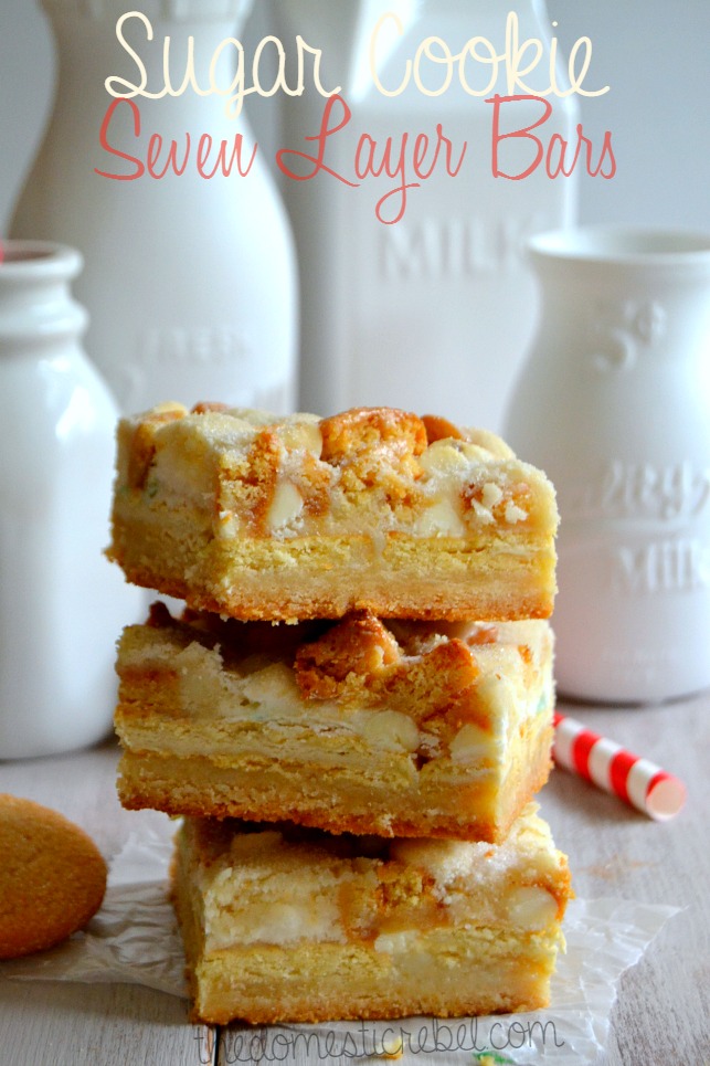 Sugar Cookie Seven Layer Bars stacked against white milk glass bottle background