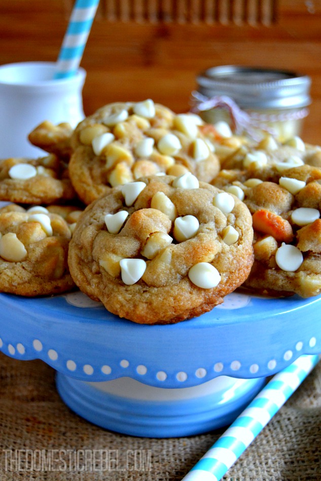 White Chip Macadamia Cookies arranged on blue cake stand on wood background
