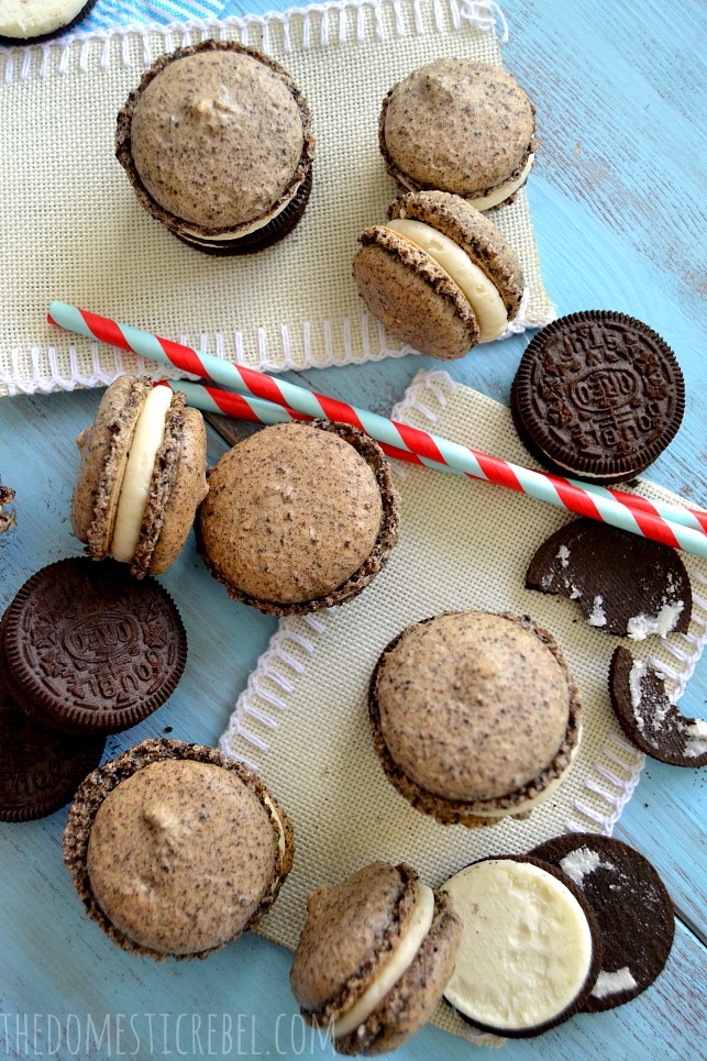 Oreo Macarons arranged on blue and tan background with Oreo cookies and blue and red straws