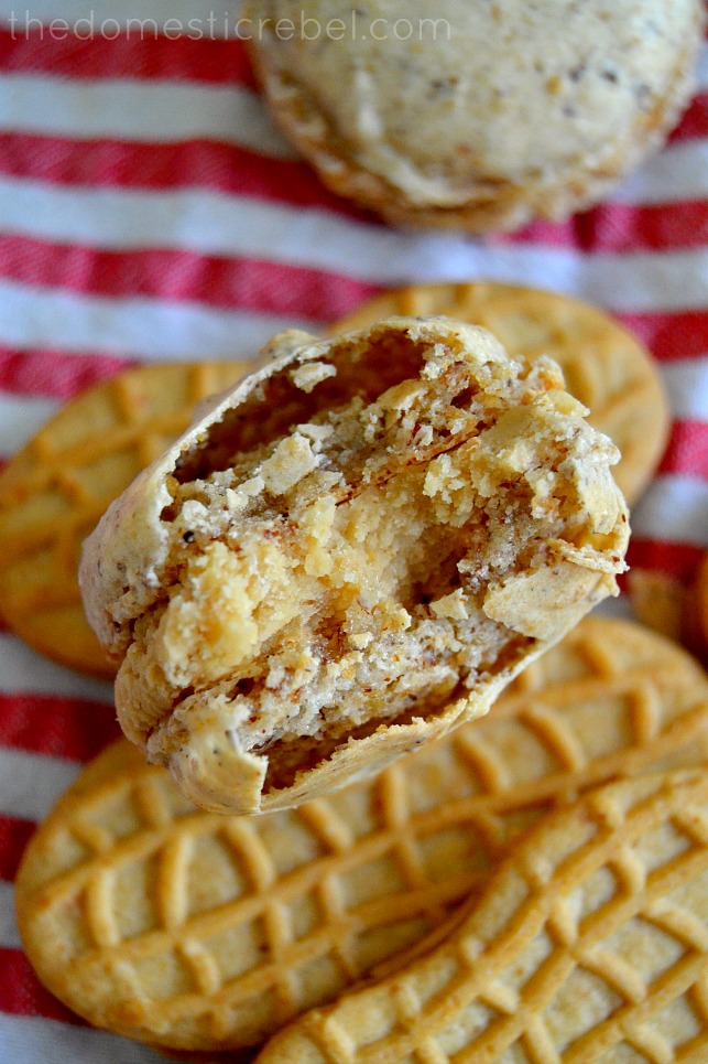 photo of a just-bitten nutter butter macaron sitting on nutter butter cookies