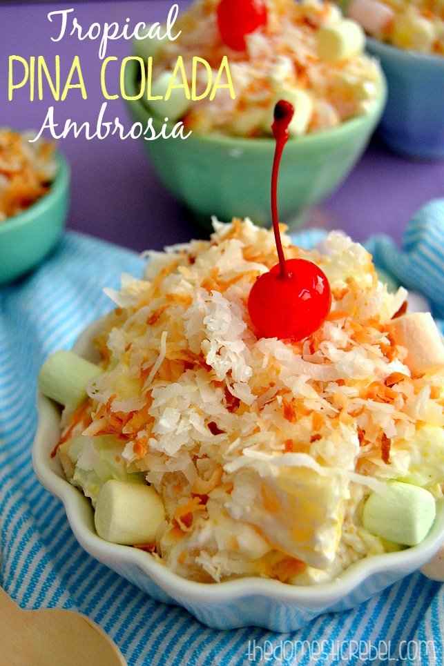 tropical pina colada ambrosia salad in a white dish with bowls in background