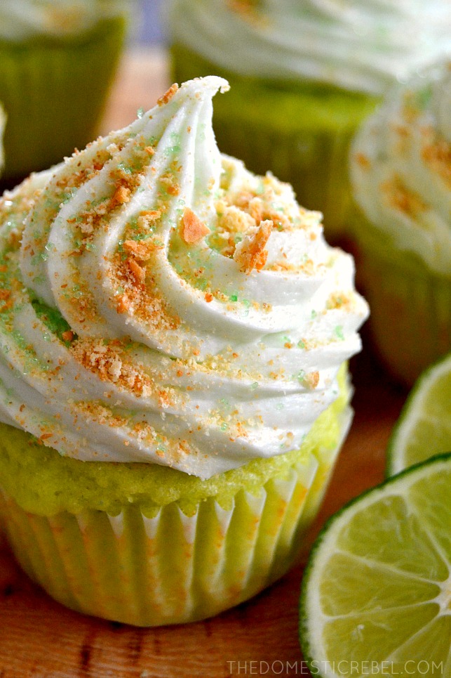 key lime pie cupcake on a wooden stand with limes