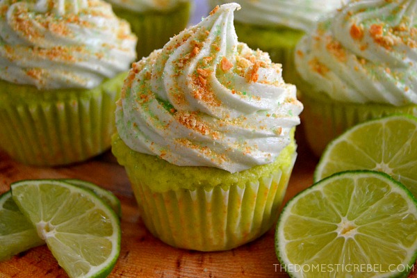 key lime pie cupcakes with lime wedges on wood