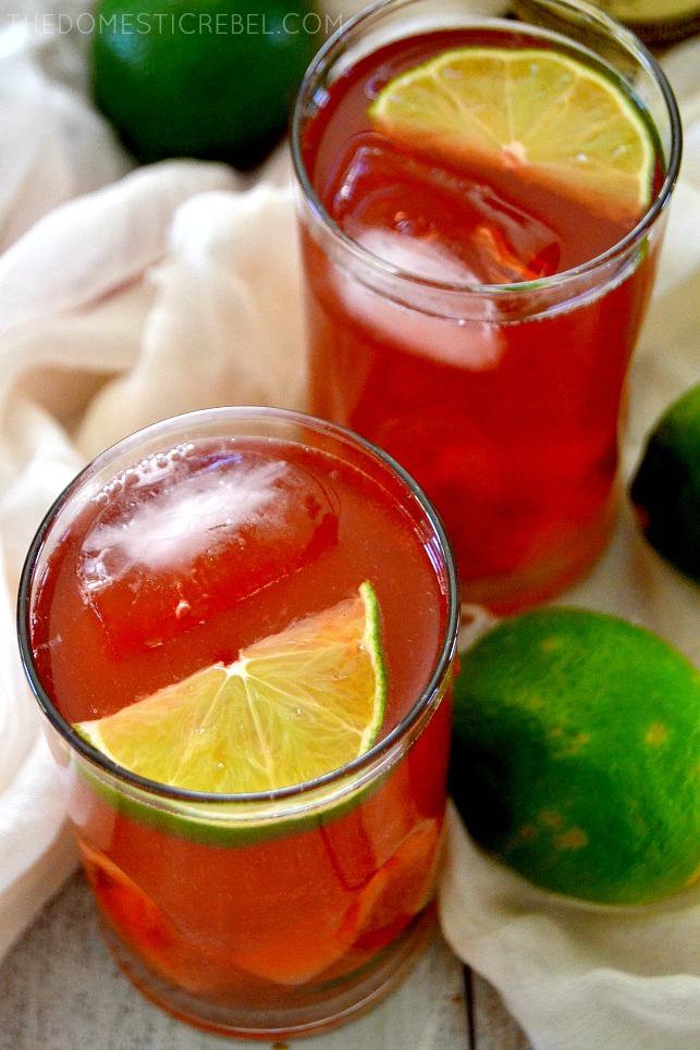 Two glasses of cherry rum punch in white fabric with limes