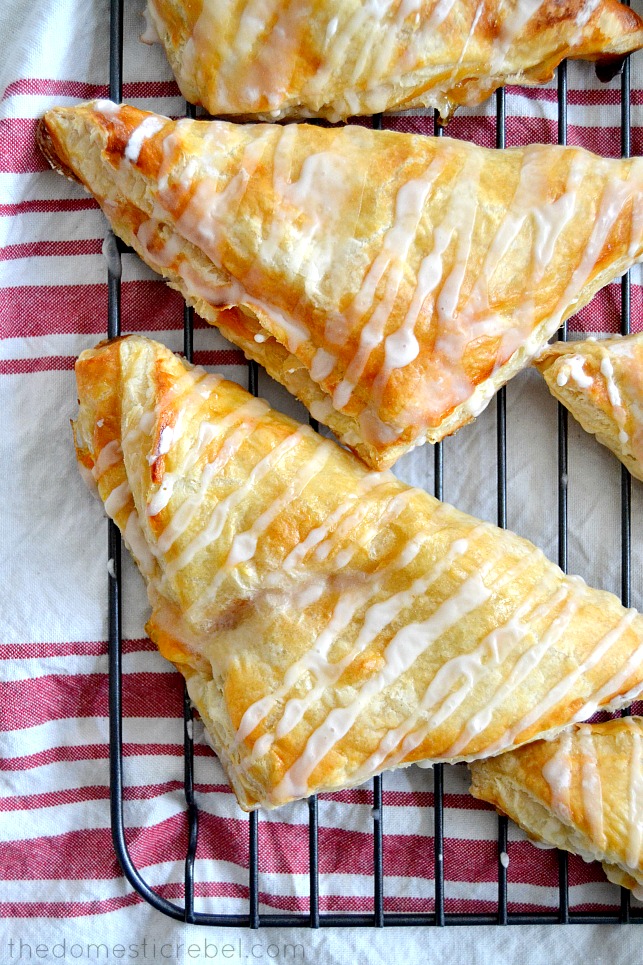 Peach Turnovers lined up on wire rack with fabric underneath