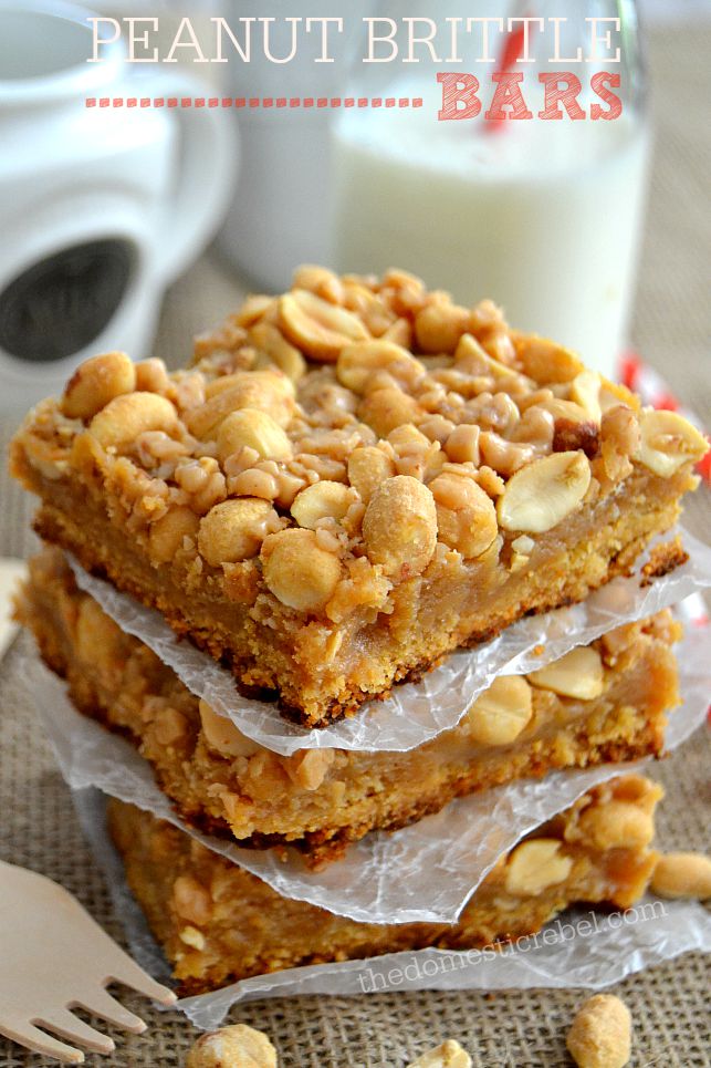 Peanut Brittle Bars stacked on parchment paper with glass of milk in background