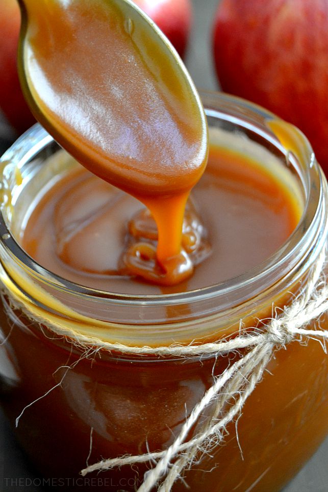 Salted Caramel Sauce in a jar with twine and a spoon drizzling the sauce