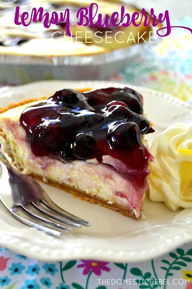 Lemon Blueberry Cheesecake slice on white plate with fork and lemon wedge