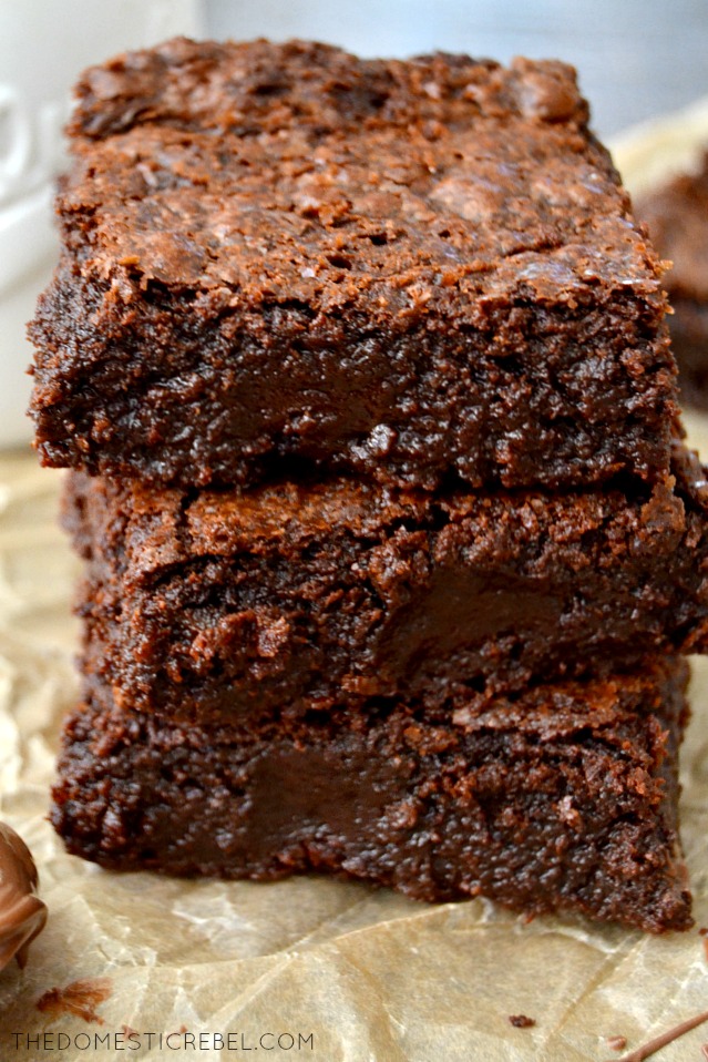 Triple Chocolate Nutella Brownies stacked on parchment paper