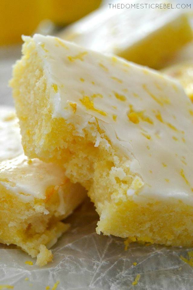 Closeup of Fudgy Lemon Brownies with bite missing on parchment paper