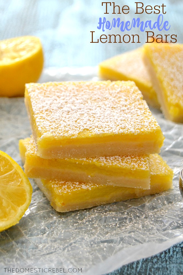 Lemon Bars stacked on white parchment with powdered sugar and lemon slices