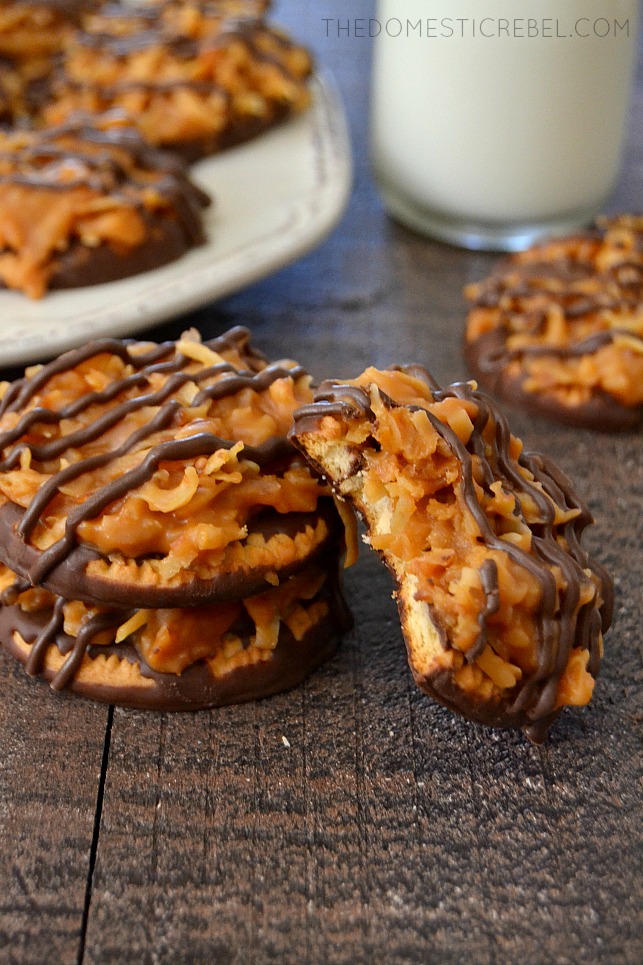 Samoas Cookies stacked on wood background with plate and milk