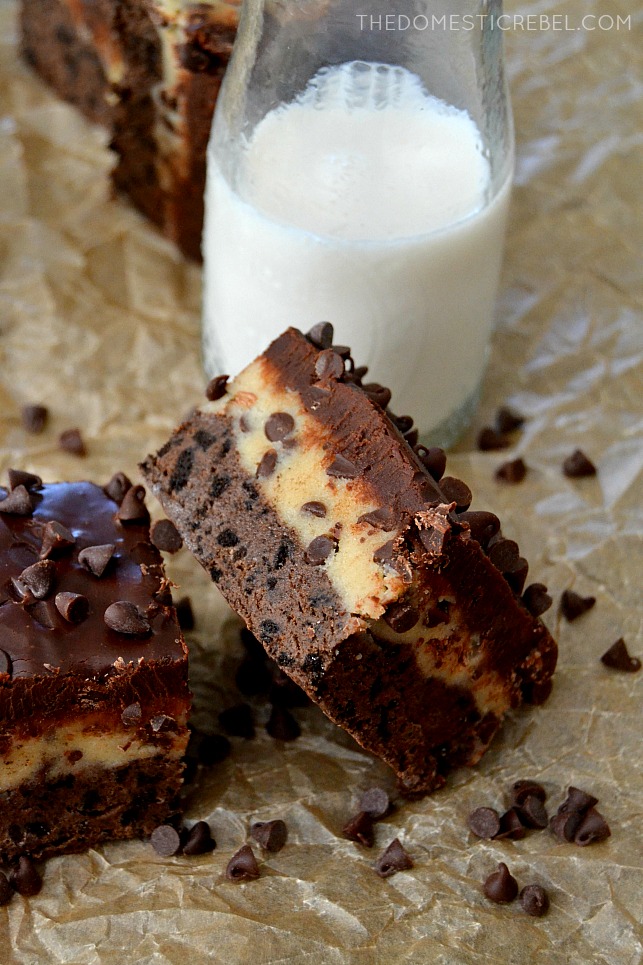 Cookie Dough Brownies arranged on parchment with choc chips and milk