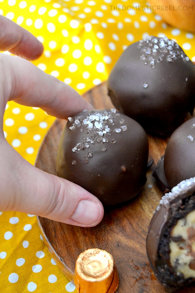 Salted Caramel Mocha Brownie Bombs on wood board with candy and yellow fabric