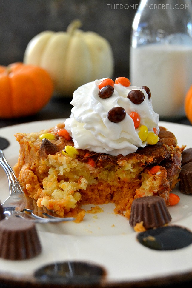 PB Cup Pumpkin Cake with fork and PB cups on white plate with pumpkins in background