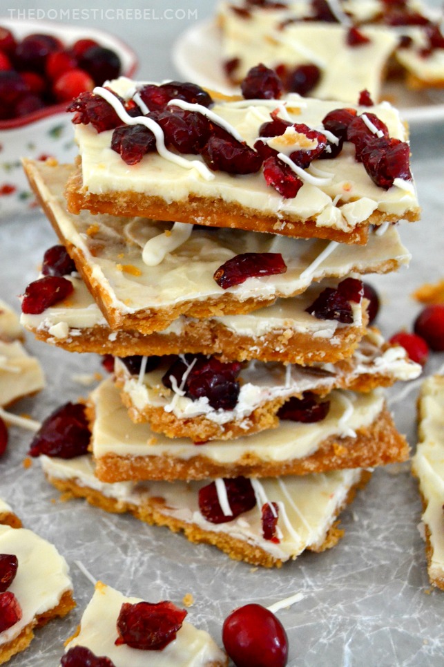 tall stack of cranberry bliss toffee on parchment with cranberries