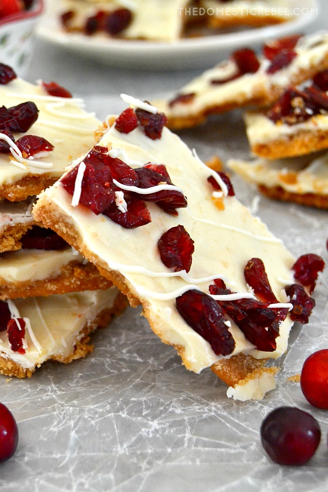 closeup of cranberry bliss toffee arranged on parchment with fresh cranberries