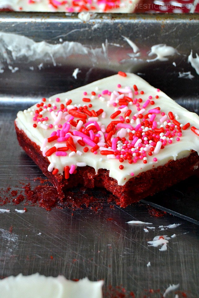 Slice of Red Velvet brownie with red, white, and pink sprinkles and a bite taken out of it.