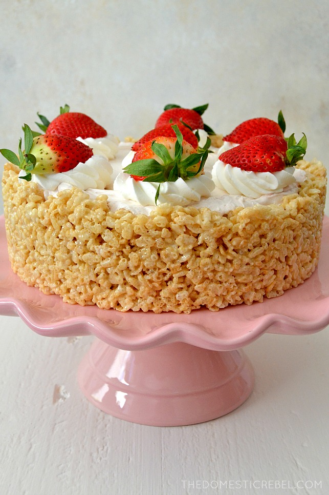 Whole Rice Krispy Treat Strawberry Cheesecake on a pink cake stand.