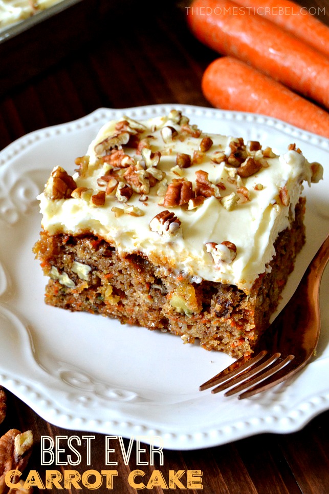 Slice of carrot cake on a white plate next to a fork