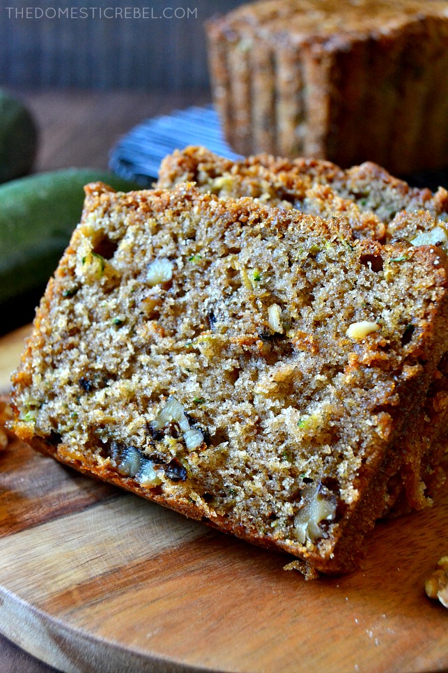 CLOSE UP VIEW OF A SLICE OF ZUCCHINI BREAD ON A WOOD PLATE