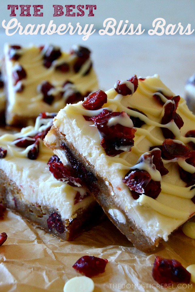 Two cranberry bliss bars propped against each other on parchment paper