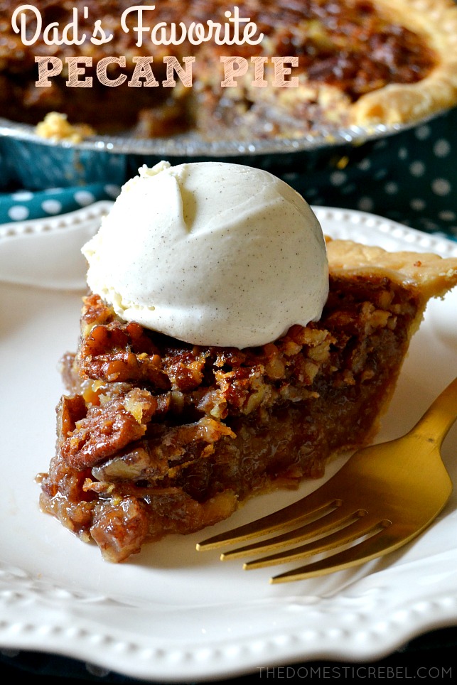 bourbon pecan pie slice with a huge dollop of whipped cream on top of a white lacy plate with a gold fork