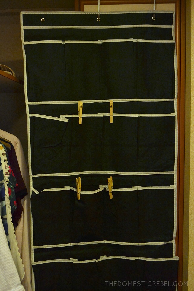 a black over-the-door shoe organizer with clothespins on it