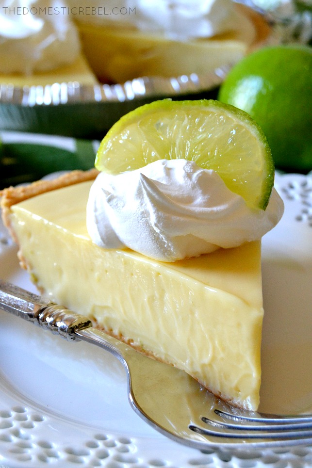 slice of key lime pie on a white plate next to a fork
