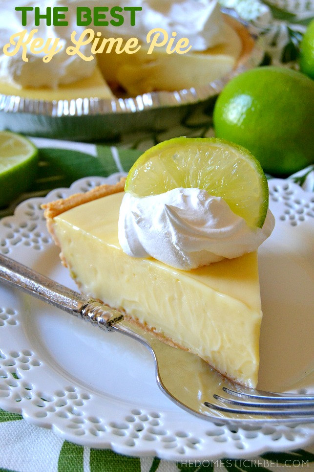 key lime pie slice on white plate with fork and limes