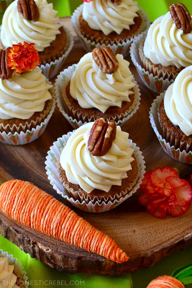 aerial view of carrot cake cupcakes on wooden cake stand next to faux carrot