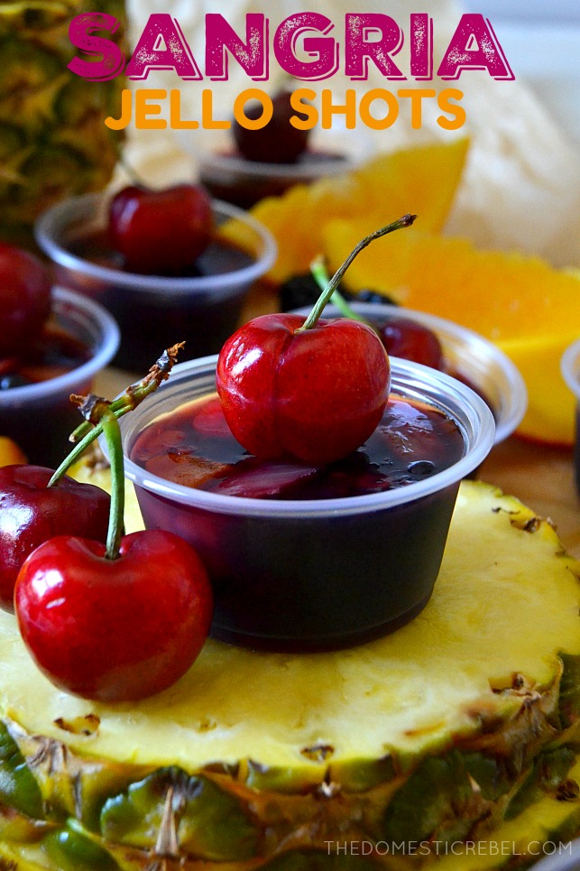 sangria jello shot in a small, plastic cup topped with a cherry 