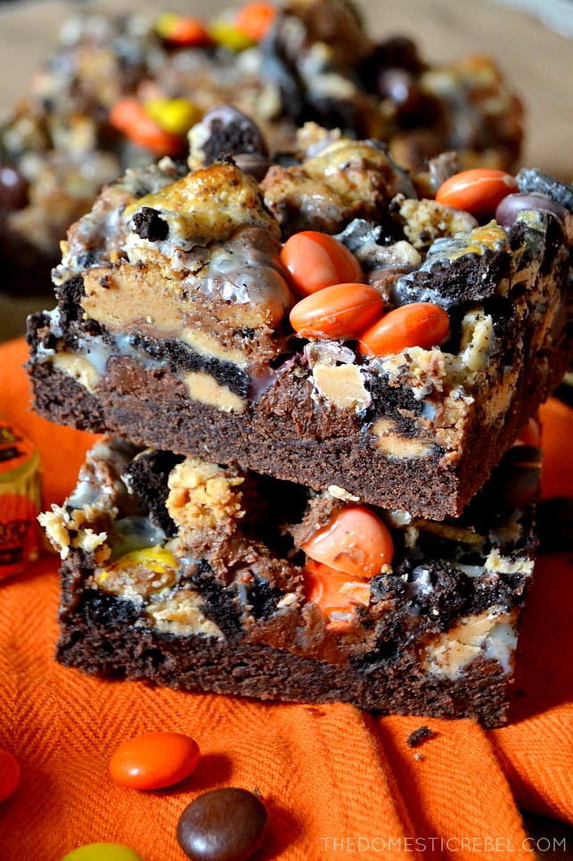 two peanut butter cup magic bars stacked on an orange towel 