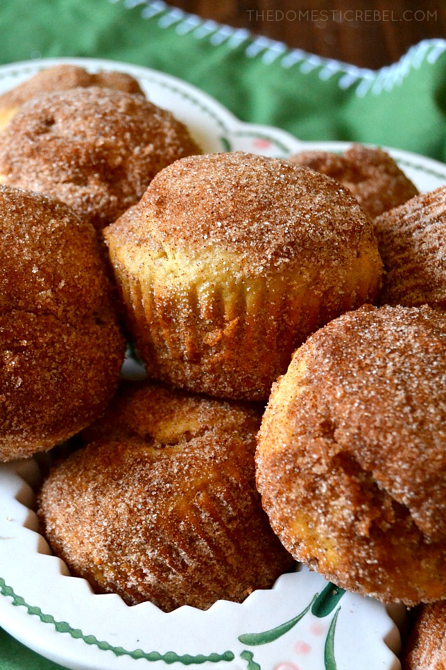 churro donut muffins piled on top of the ceramic muffin pan 
